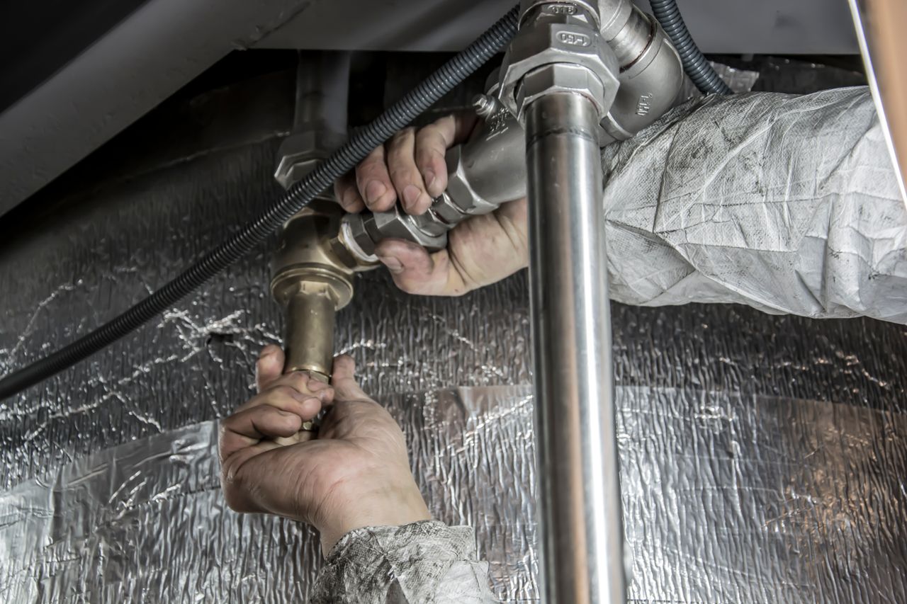 brand-02 Close-up of a plumber's hands installing steel pipes indoors, showcasing skilled manual work.